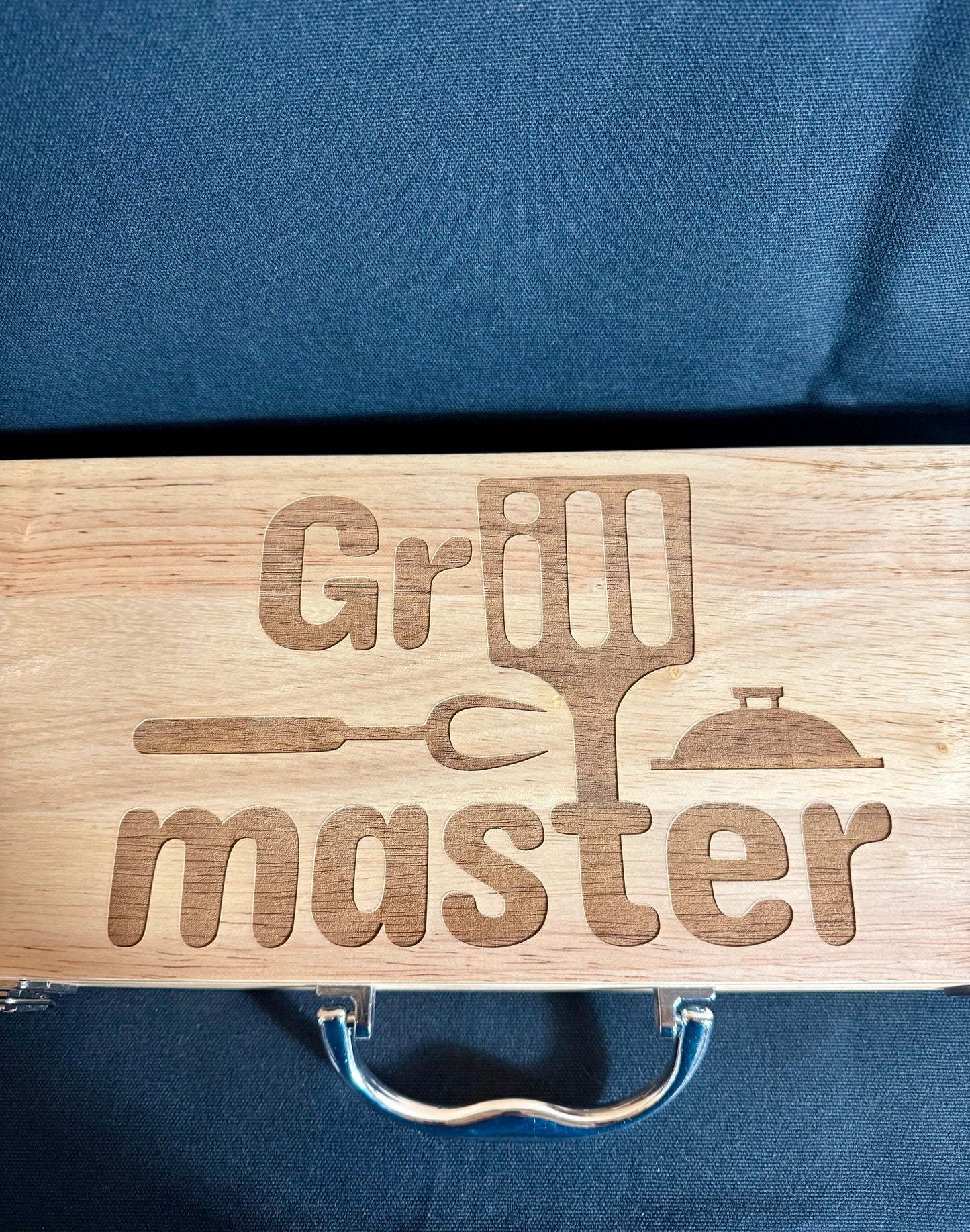 Grill Master engraved on top of the case. comes with a nice handle and a lock on either side other of the case to insure it won't open up.