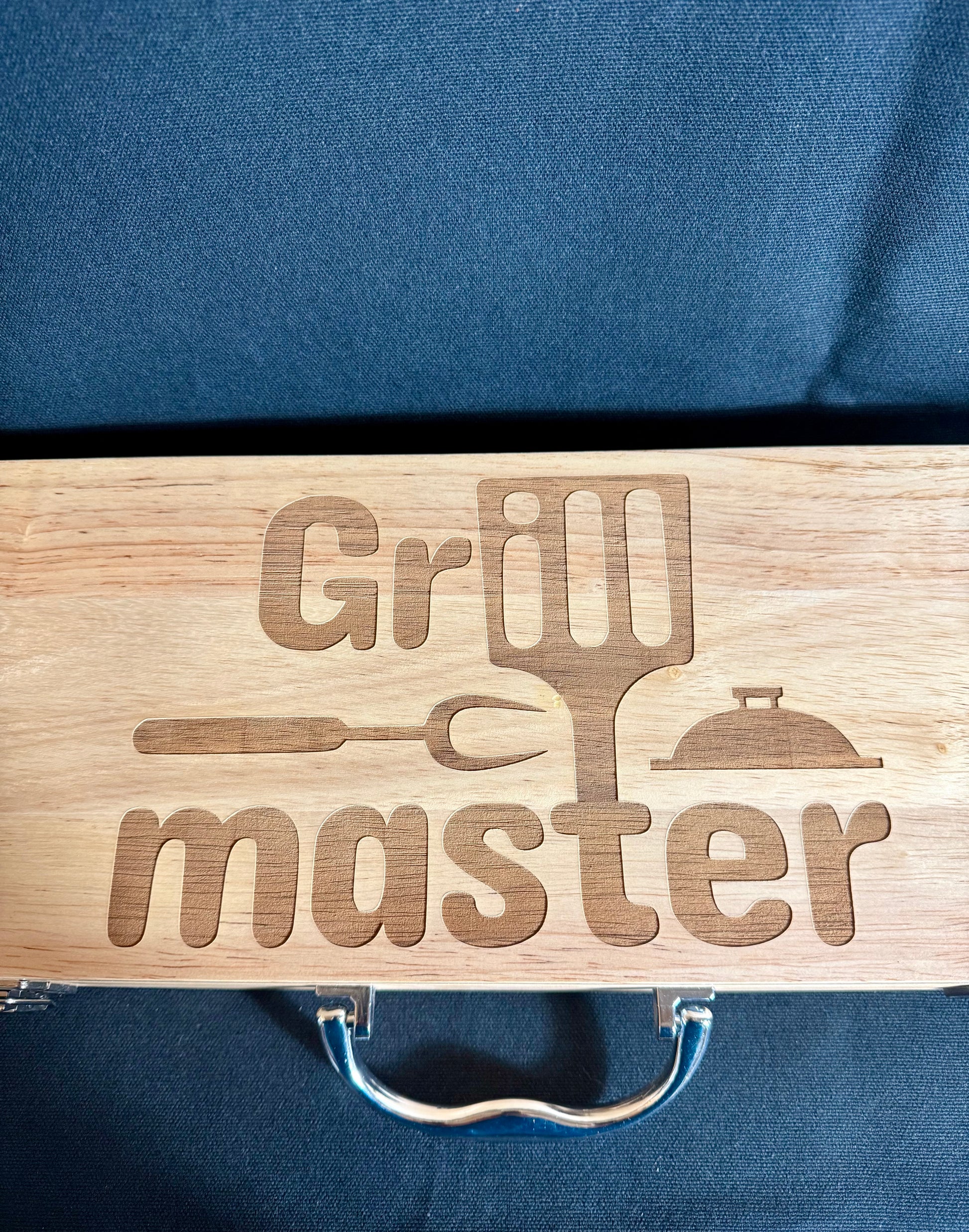 Grill Master engraved on top of the case. comes with a nice handle and a lock on either side other of the case to insure it won't open up.