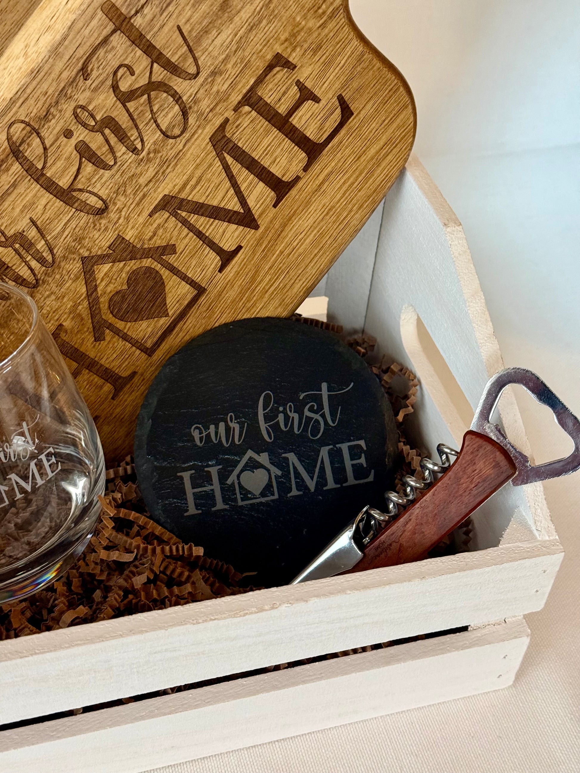 Gift set with 'our first home' engraved items in a wooden box.