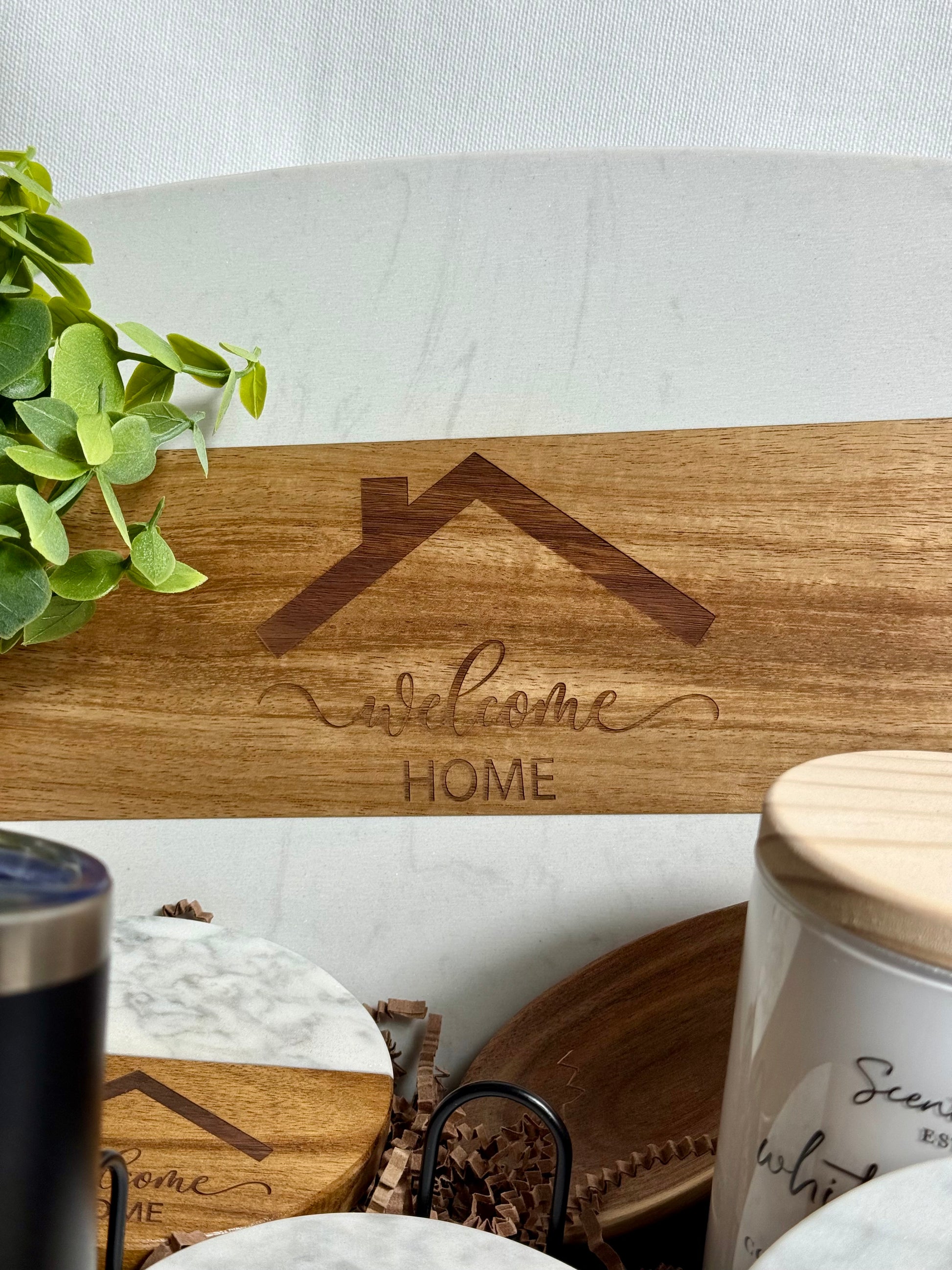 Welcome Home engraved on a white marble cutting board.
